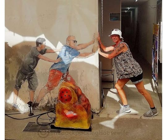 Backpacking Housewife. Two guys are pushing a door. This mural is located next to Penang umbrella street