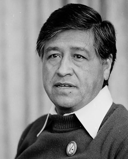 Cesar Chavez, head and shoulders portrait, facing just to left of camera, wearing a dark sweater with a white collared shirt underneath.