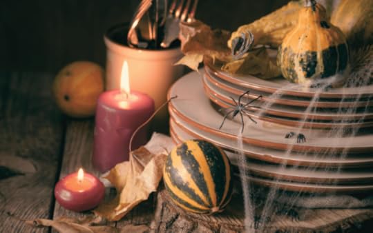 Halloween themed dinner plates and a candle and plastic spider