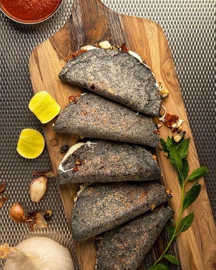 Five huitlacoche quesadillas on a board, ready to eat.