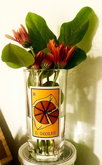 orange flowers (mums?) in a glass from mole sauce that says el chocolate
