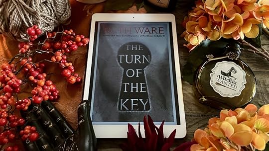 Book The Turn of the Key surrounded by fall flowers and gothic potion bottles
