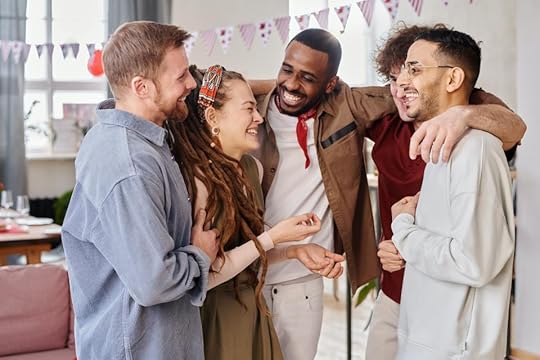 A diverse group of four friends joyfully interacting in a bright, festive indoor setting, with decorations in the background.