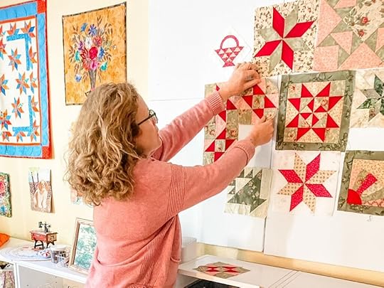 Marie hanging a square on her Easy DIY Quilting Design Wall Board