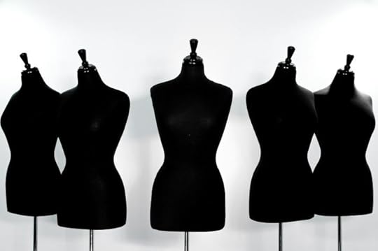 A white background with 5 headless mannequins in black fabric