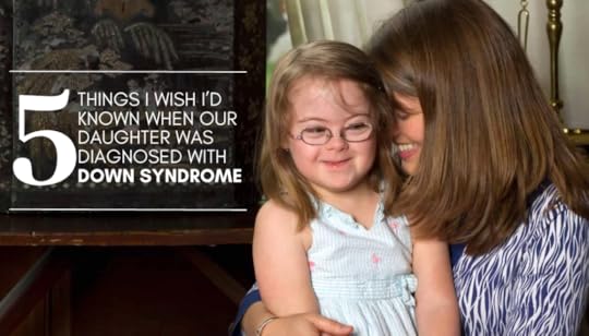 photo of Amy Julia smiling and leaning her head against Penny's head, who is a young girl with Down syndrome. She sits on Amy Julia's lap.