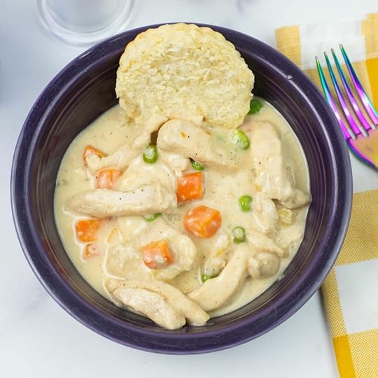 Instant Pot Chicken a la king served over a buttermilk biscuit in a bowl.