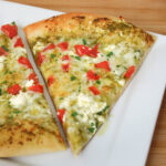slices of pesto pizza on a white plate.