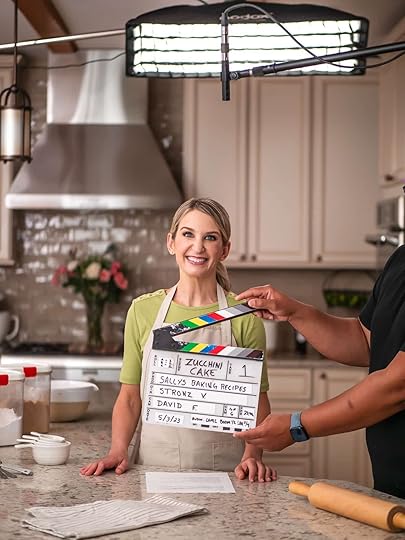 Sally wearing green shirt and khaki branded apron with videography marker in place.
