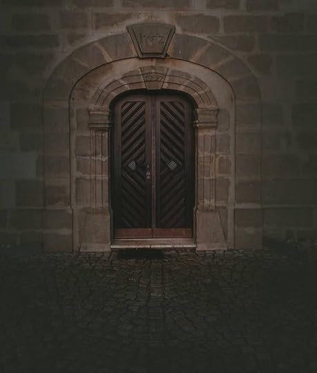 An old door in a dark stone wall