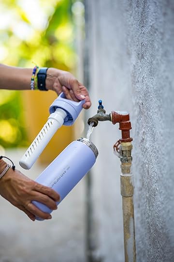 person filling lifestraw water bottle from faucet
