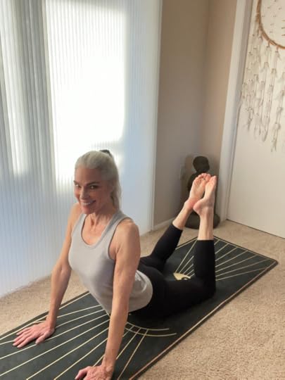 Roxanne stretching on a yoga mat, smiling.