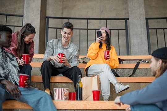 A group of young, ethnically diverse people sitting on a bench. Make your characters seem real to improve your world-building for YA fiction.