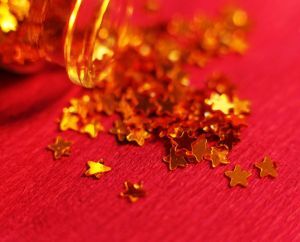 Pile of small gold stars on a red background