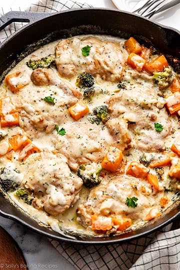 chicken, broccoli, and butternut squash in creamy garlic sauce with fresh parsley in cast iron skillet.