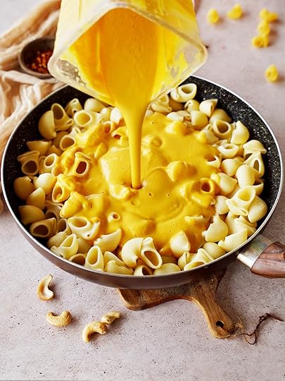 pouring vegan butternut mac and cheese into black skillet