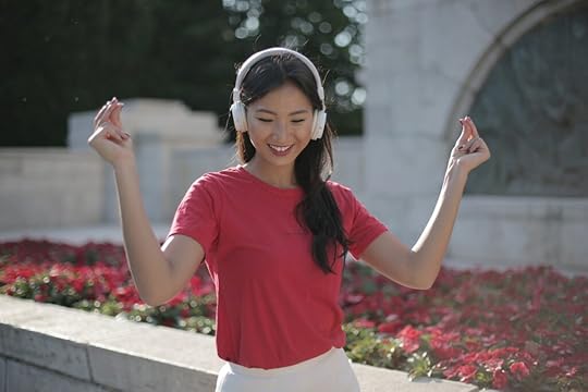 A woman dancing while listening to music. Self-expression is an important change you can write for your YA hero's growth.