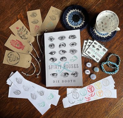 Range of Spirit Houses X merch arranged on a table