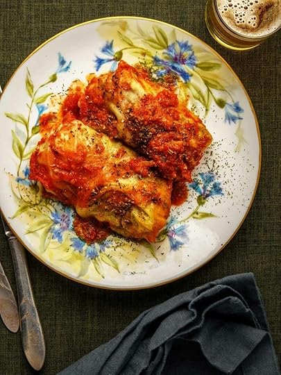 Two golumpki, Polish cabbage rolls, on a plate with tomato sauce.