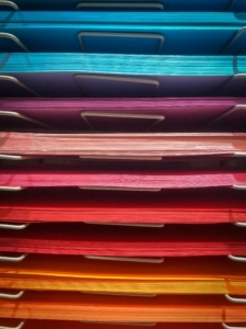 Colorful papers neatly stacked and ordered by color, which is much easier than a writer ordering scenes and chapters for their novel writing return.