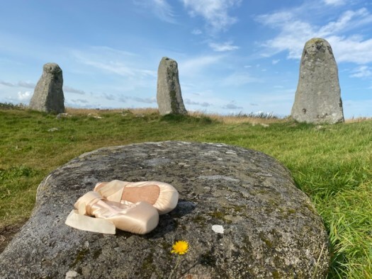 ballet shoes on a standing stone