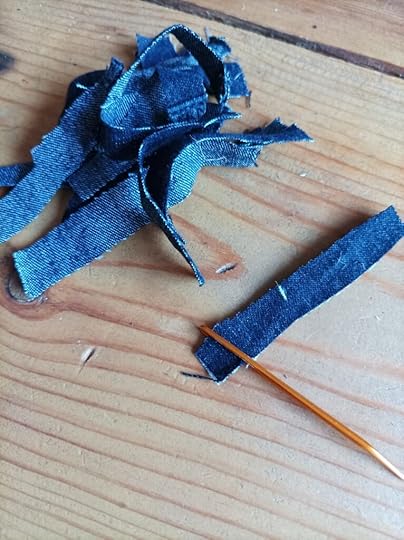 A pile of denim steps with a needle
