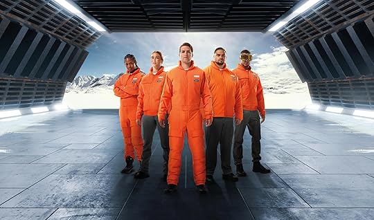 Five people standing in a V wearing orange Columbia Star Wars Luke Skywalker pilot gear against the open door of a star ship with snow behind