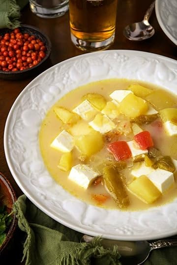 A bowl of caldo de queso with chiltepins and a beer.