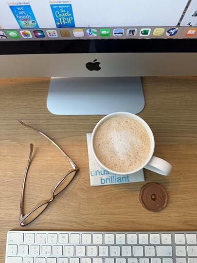 Photo shows a coffee sip and a chocolate biscuit on a desk. 