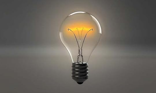 illuminated lightbulb against gradiated gray backgorund.