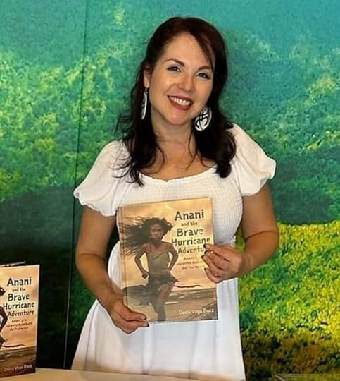 Author Doris Vega Baez holding a copy of her children's book