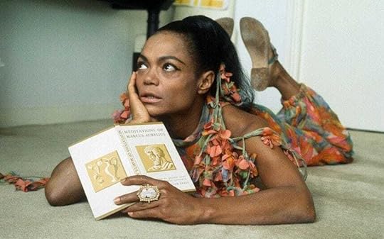 Eartha Kitt lies on the floor reading 