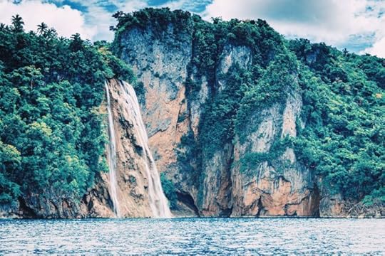 Waterfall cascading down a tropical cliff into the Philippines sea