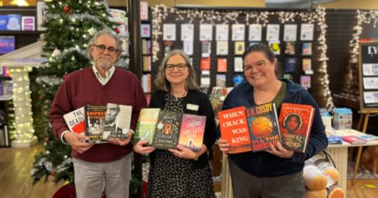 Andy, Rae Ann, and Chelsea pose with their favorite books of the year in front of the Parnassus Christmas tree