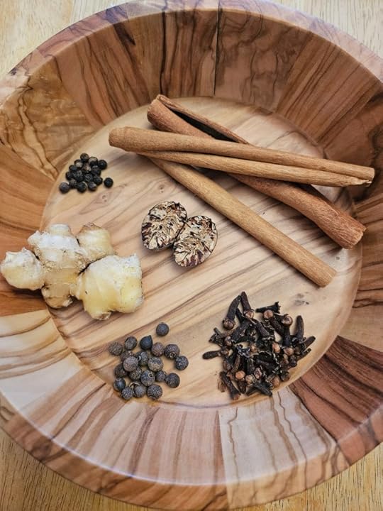 Bowl of whole spices for chai tea, cinnamon sticks, nutmeg, cloves, allspice, ginger root and peppercorn