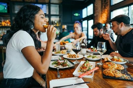 woman eating at a table with others. choosing everything you consume.