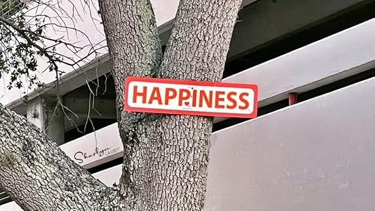 sign posted on a tree saying happiness for workplace wellbeing