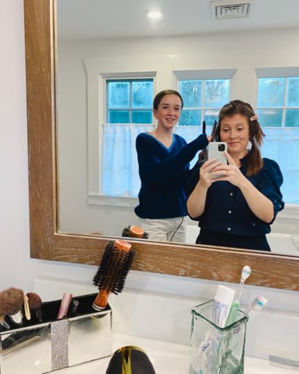 Amy Julia takes a selfie in the mirror as Marilee does her hair