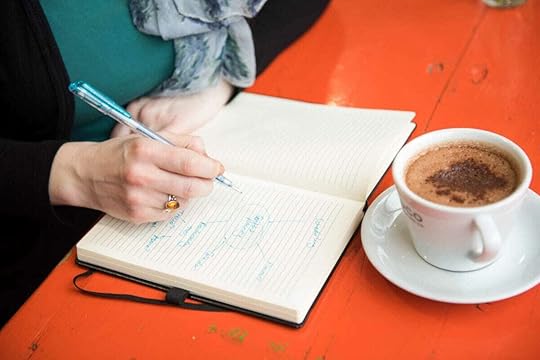 Coffee cup and notebook, Elizabeth writing in notebook