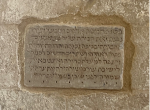 A stone plaque with text on itDescription automatically generated
