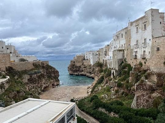 A group of buildings on a cliff by the waterDescription automatically generated