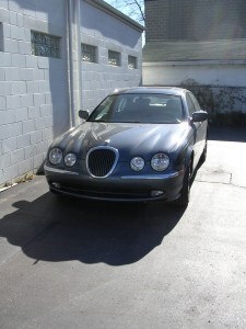 Jaguar parked by garage