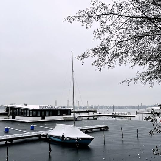 Ein eingeschneites Segelboot unter einer Persenning an der Alster