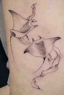 A tattoo of two manta rays swimming 