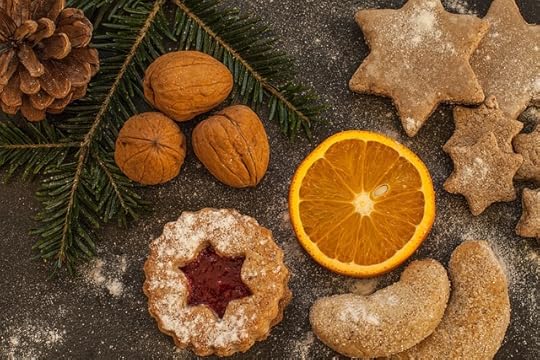nuts, pine cone, evergreen, start shaped cookies, and an orange slice, decorated with powdered sugar.