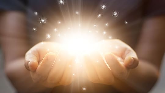 A pair of hands holding a glow of energy with stars coming off of it