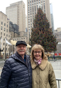 Author Elinor Florence and husband stand in front of Rockefeller Center Christmas tree, 2023