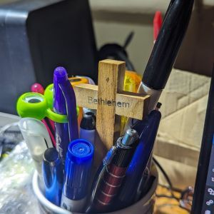 Cross sitting in a pot of pens.