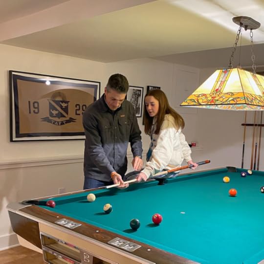 Peter teaching marilee to play pool