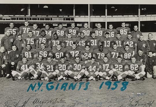 A black and white team picture, with players posed in full gear, sitting or standing in four rows.